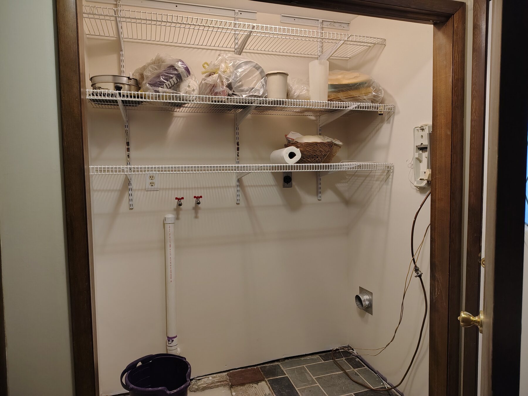 Laundry room opened for plumbing access before wall restoration